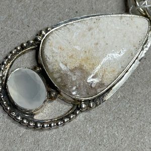 large sterling pendant with crystal and white stone.